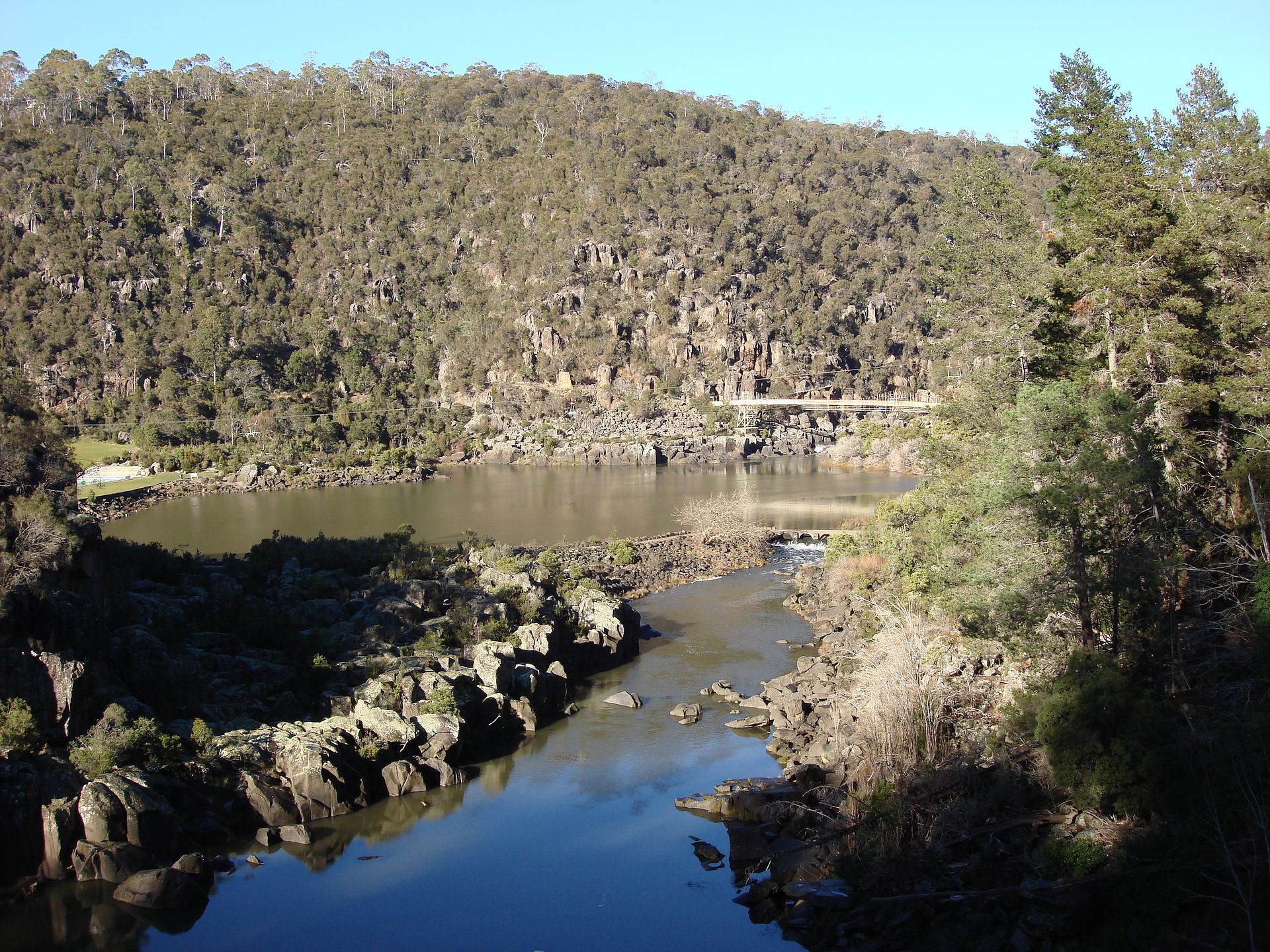 The Cataract Gorge is a river gorge in northern Tasmania, near Launceston, and is one of the region's premier tourist attractions. A pathway, known as the King’s Bridge-Cataract Walk, and originally built by volunteers in the 1890s, runs along the north bank of the Cataract Gorge, and is a popular tourist destination. The chairlift crossing the Gorge is the longest single span chairlift in the world, with the longest span being 308m (924 ft). The chairlift, built in 1972, has a total span of 457m. Before the Hydro Dam was built in the 1950's upstream, flood waters could rise up as high as 12 metres. In the past, there was a power station at Duck Reach, about 2.5 kilometres from the suspension bridge. It was washed away in the floods of 1929, rebuilt and then decommissioned when the new Hydro Dam was finished in 1955. The building is now an interpretive museum. The First Basin on the southern side features a swimming pool and an open area surrounded by bushland. At the lower end of the Gorge, the South Esk spills into the Tamar River going under Kings Bridge on the way. This was the only bridge leading north out of the city for nearly 100 years. [Wikipedia.org]