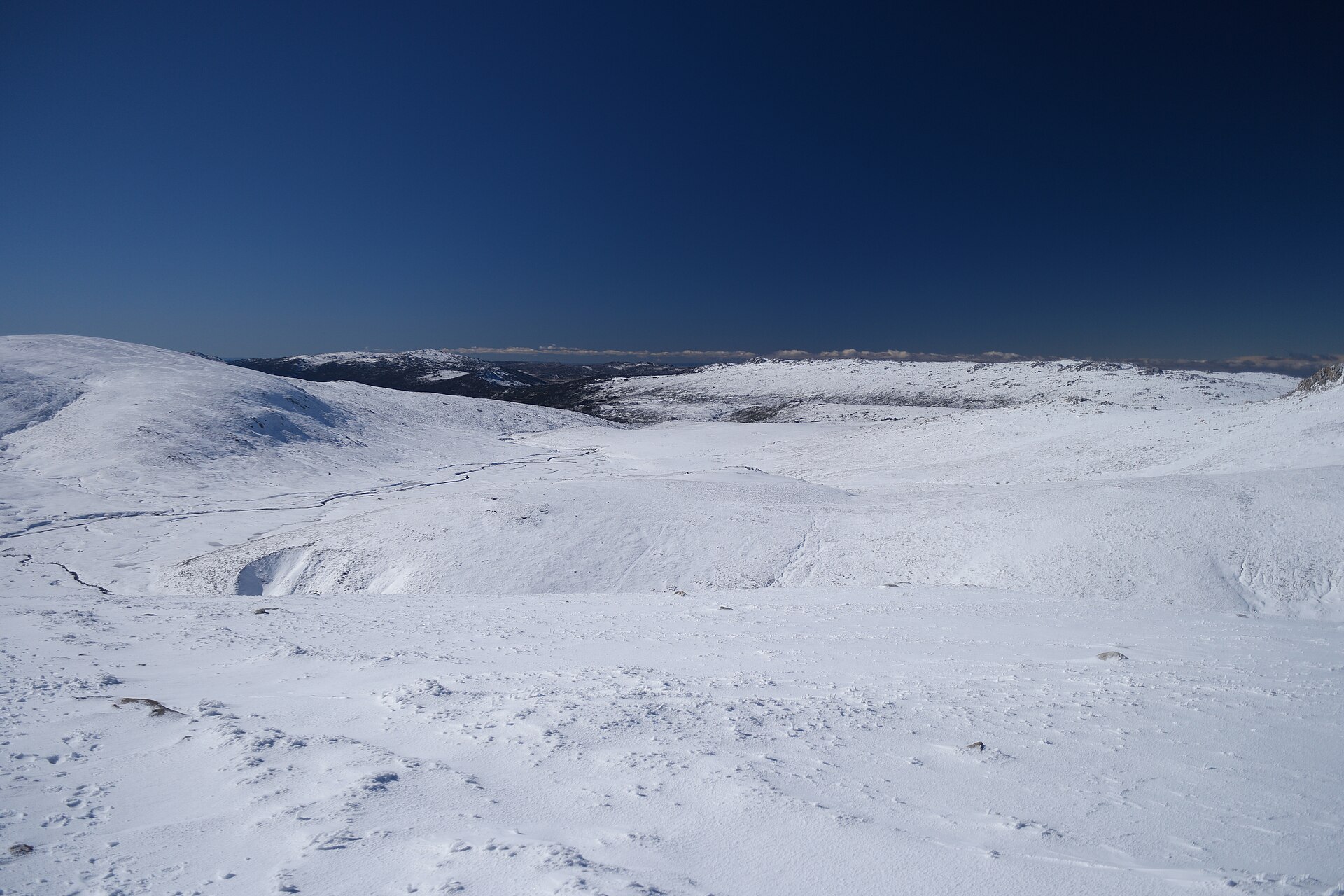 View toward Charlotte Pass, Mount Stilwell and Etheridge Ridge from the side of Mount Kosciuszko, Main Range Track, Kosciuszko National Park, New South Wales, Australia. Mount Clarke is to the left.