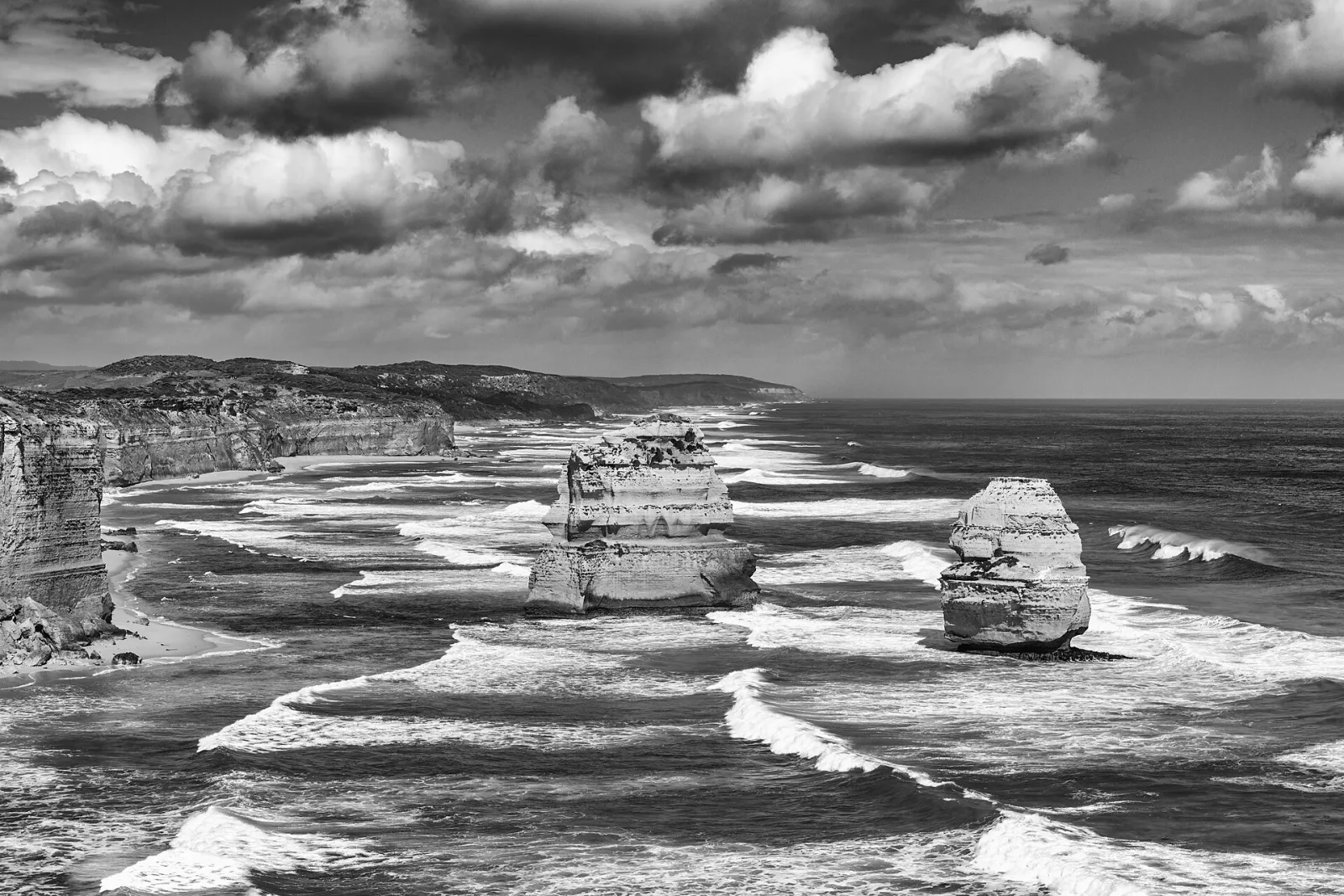 Twelve Apostles at Port Campbell National Park, Princetown, Victoria, AustraliaPort Campbell National Park is located on the south coast of Victoria along the Great Ocean Road and protects a spectacular coastal landscape of limestone, cliffs, caves, and natural bridges.Its geological formation dates back millions of years: over thousands of years, layers of limestone and shells formed caves, gateways, and towers, which were repeatedly eroded by the Southern Ocean. The coast also served as a habitat for indigenous groups in the region, including the Wergaia and Eastern Maar communities. From the 1950s/60s onwards, the area was designated a protected area to preserve its exceptional geology, wildlife, and flora and to manage visitor flows in a sensible manner.Special features include the famous limestone cliffs, narrow passages, natural bridges, and steep cliffs; highlights such as the Twelve Apostles, Loch Ard Gorge, and other coastal formations attract many visitors each year. The sea is home to seals, seabirds, and rich marine fauna, while the rocky shores also support maritime flora. Hiking trails, lookout points, and boat tours offer insights into geology, geomorphology, and coastal protection—a harmonious combination of natural wonders and historical perspective.